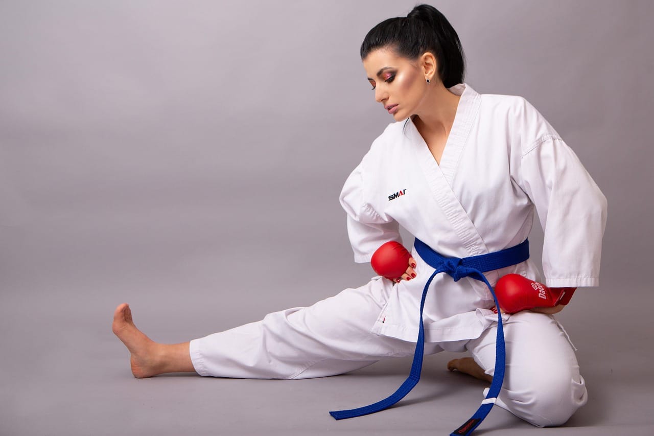 A fit martial artist practicing high-intensity kicks and punches in a gym, showcasing strength, endurance, and agility.